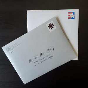 Silver and white envelopes with presort standard postage stamps